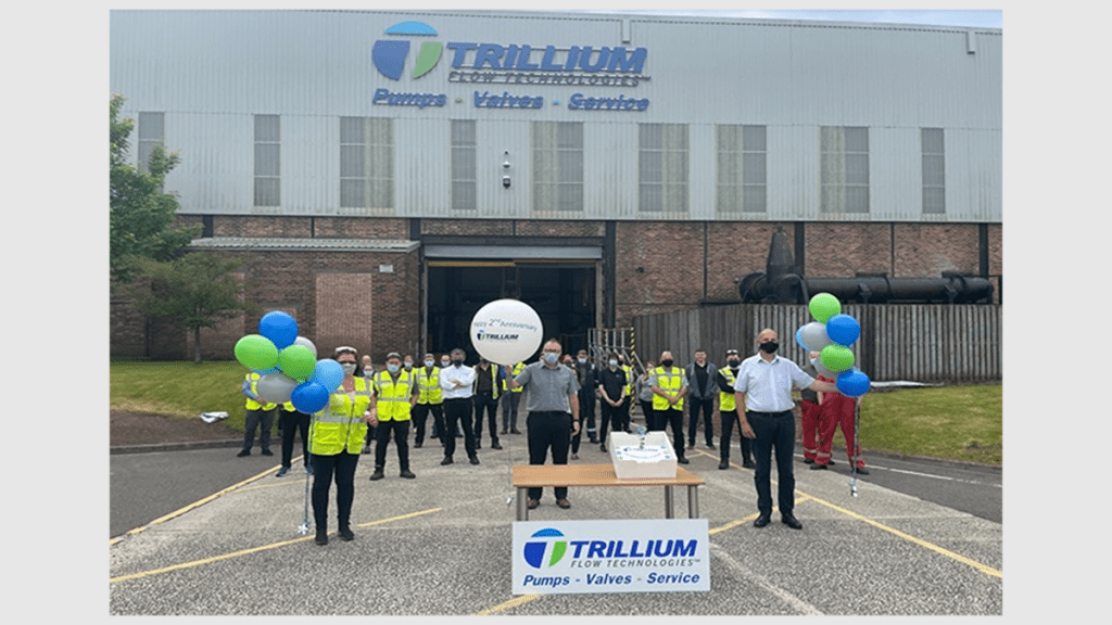 Trillium Employees celebrating second anniversary in front of site